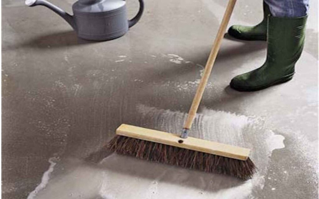 A person actively cleaning the floor with a broom, ensuring a tidy environment.