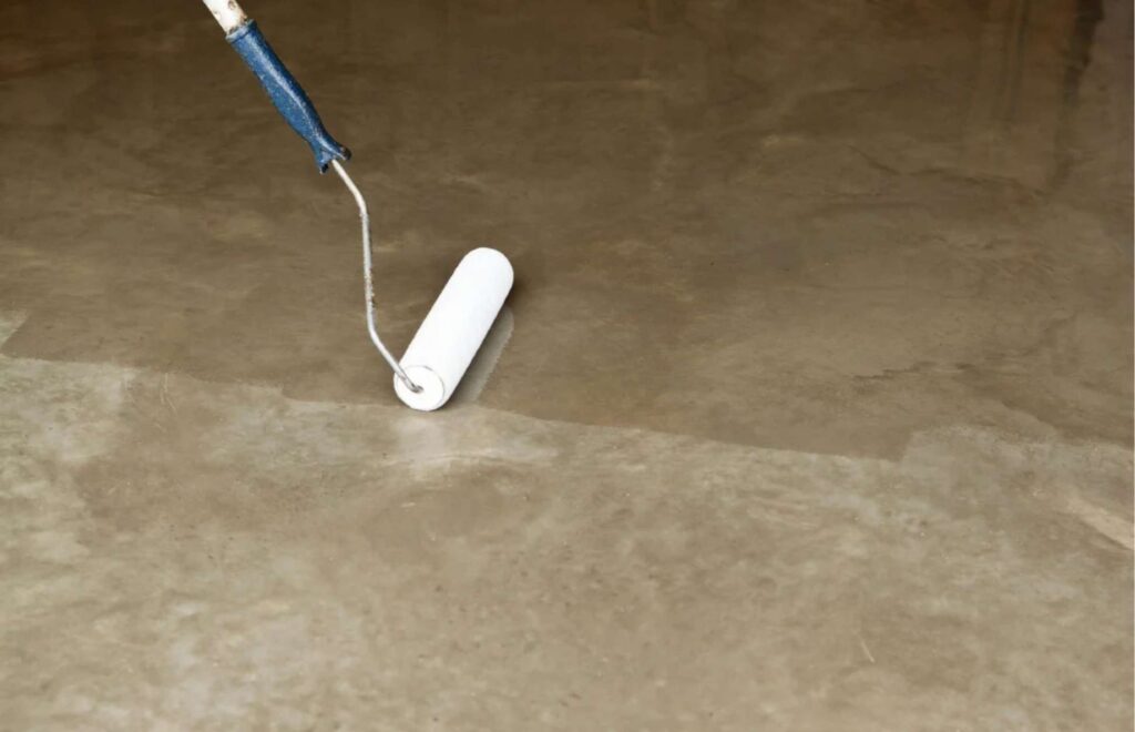 Worker Sealing Clean Concrete Surface After Oil Stain Removal